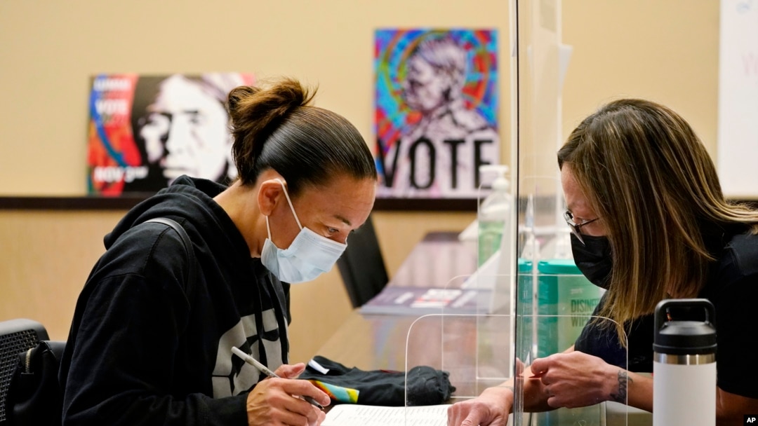 Lummi Tribal member Patsy Wilson, left, is assisted by Lummi Native Vote Team 2020 volunteer Kelli Jefferson in voting on Nov. 3, 2020, on the Lummi Reservation, near Bellingham, Washington.