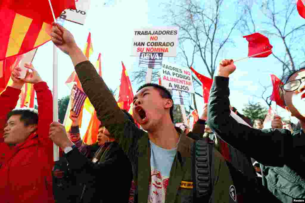 Chinese customers of Spanish bank BBVA protest outside its headquarters in Madrid, Spain. The signs read: 'The workers have not been paid their salary' (L) and 'Mothers have not been able to feed their children.'