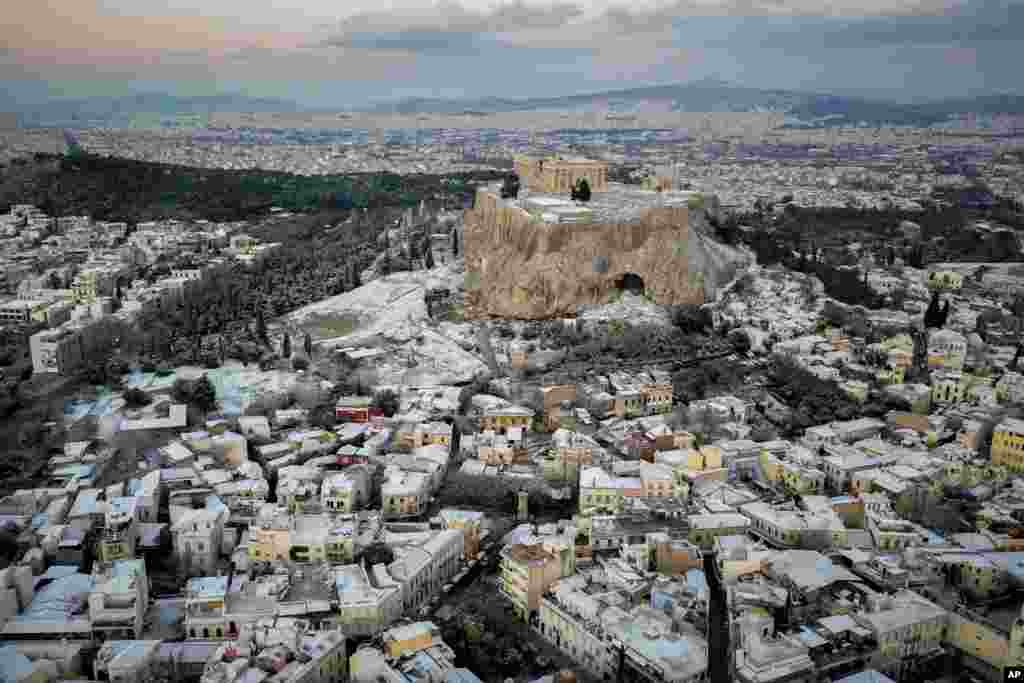 The snow covers some parts of the ancient Acropolis hill and Plaka the tourist district of Athens, Greece.