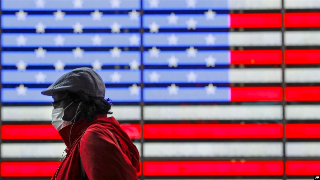 A pedestrians wearing a protective mask during the coronavirus pandemic walks along Seventh Avenue in Times Square, Saturday, May 23, 2020, in New York. (AP Photo/Frank Franklin II)