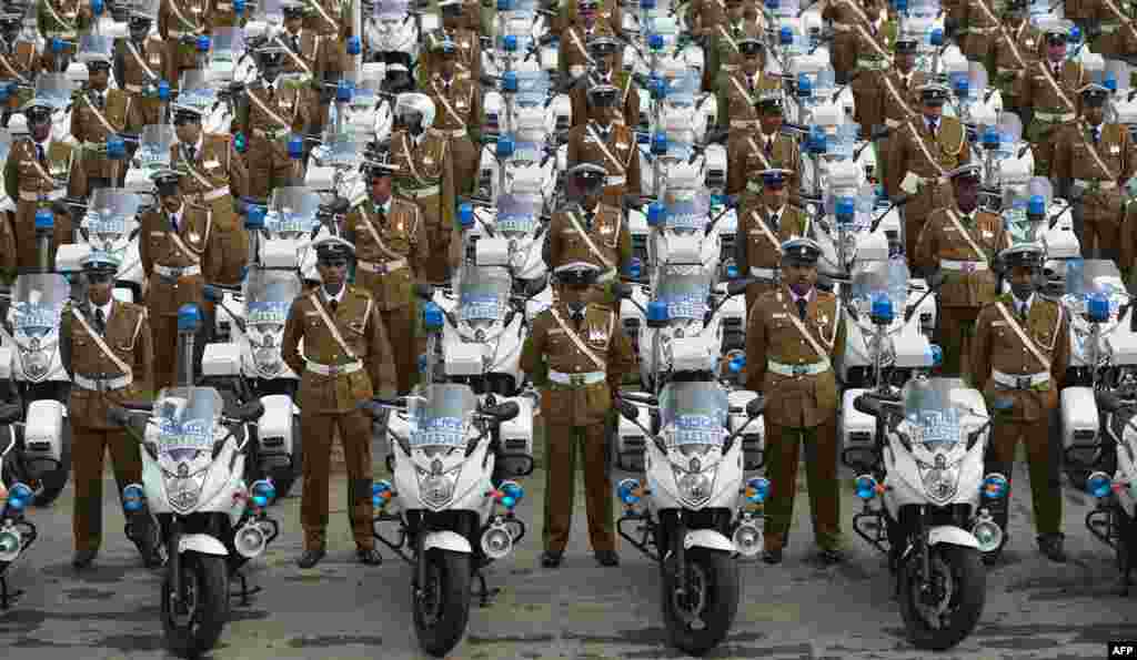 Sri Lankan policemen stand next to their new motorcycles at a ceremony in Colombo marking the official distribution of 279 high-powered units to traffic constables across the country.