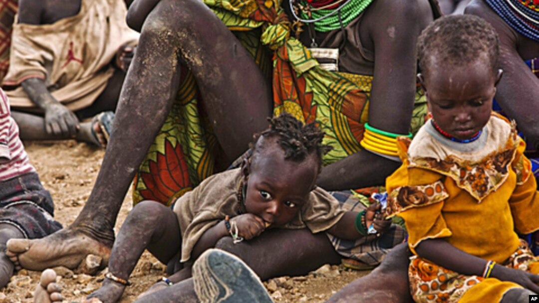 In Kenya, Turkana women and their children wait to receive relief food supplies near the Kakuma Refugee Camp, northwest of Kenya's capital Nairobi, August 8, 2011