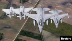 FILE - Norwegian F-16 fighters, right, and Italian Typhoon fighters patrol over the Baltics during a NATO air policing mission from Zokniai air base near Siauliai, Lithuania, May 20, 2015.