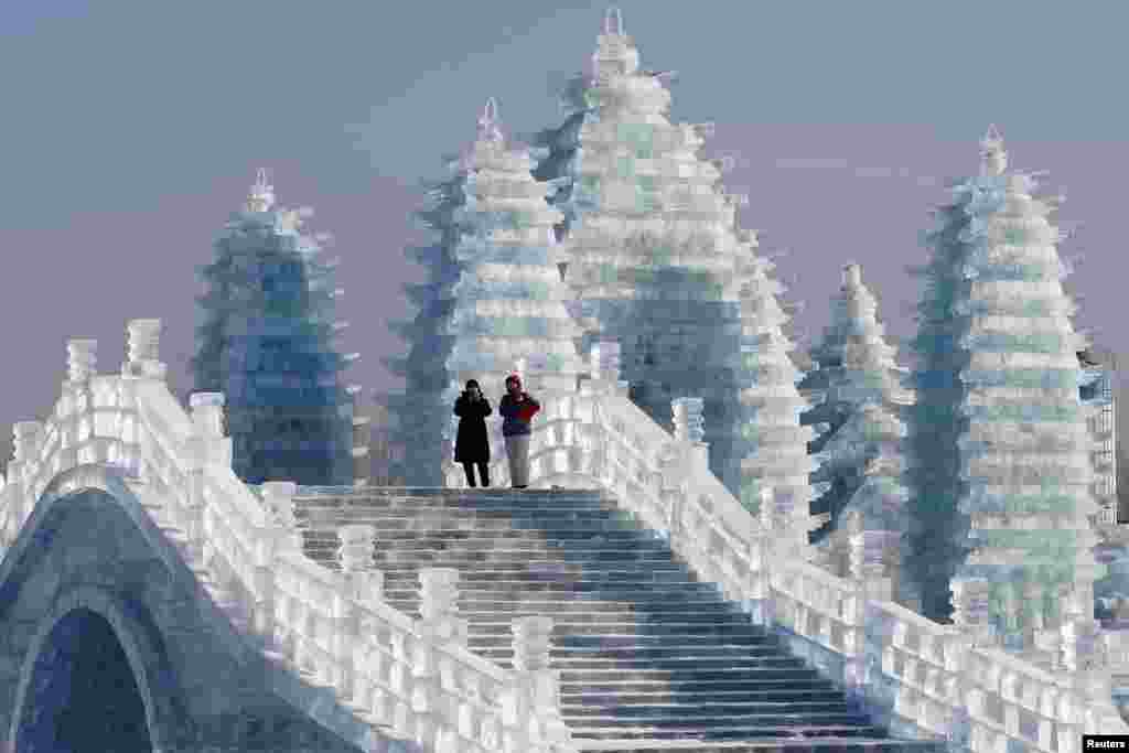 Visitors walk around ice sculptures during the annual ice festival in Harbin, Heilongjiang province, China.