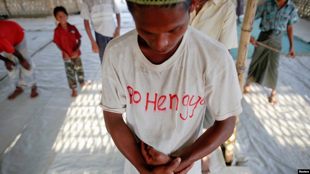 A Rohingya Muslim with the word "Rohingya" written on his T-shirt prays with others at a makeshift mosque at a camp for those displaced by violence, near Sittwe April 28, 2013.
