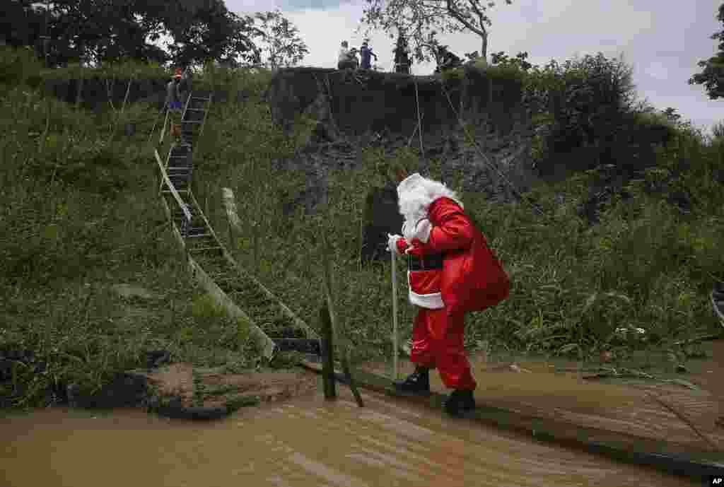 A man dressed as Santa Claus visits a community along the jungle shoreline to give out presents to children in the Amazon basin, near Careiro da Varzea, Amazonas state, Brazil, Dec. 18, 2021.