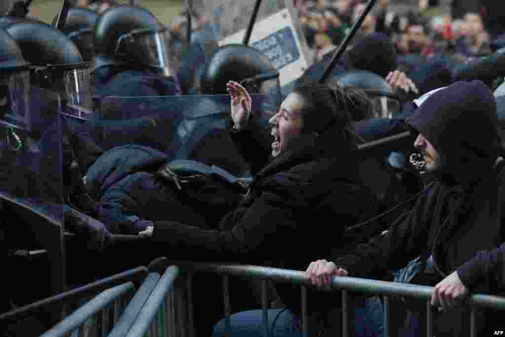 Members of the Catalan regional police force Mossos d'Esquadra try to keep protesters behind crowd control barricades during scuffles at a Catalan pro-independence demonstration in Barcelona as the Spanish cabinet held a meeting in the city.
