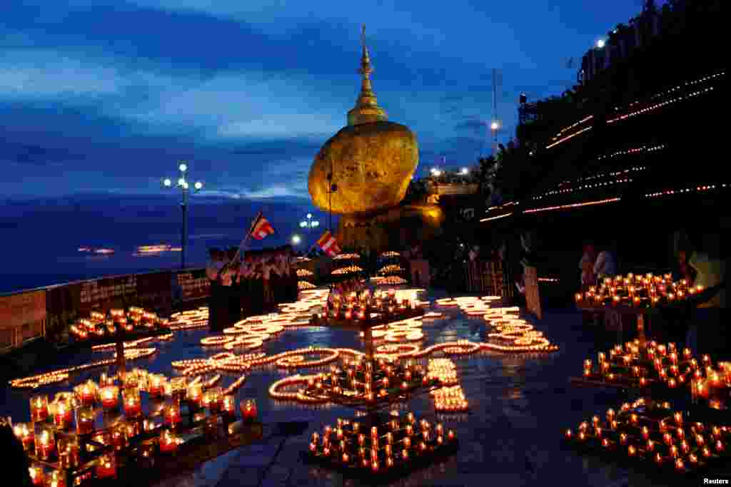 Buddhist pilgrims light candles around the Golden Rock or Kyaikhtiyo Pagoda to celebrate the full moon festival in Kyaikto, Mon state, Myanmar.