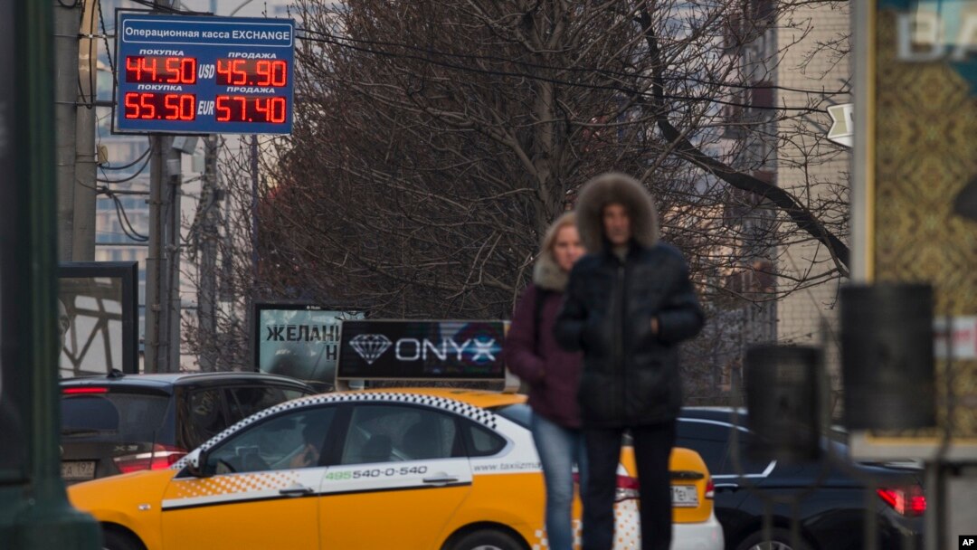 People pass by a display with exchange rates in downtown Moscow, Nov. 10, 2014.