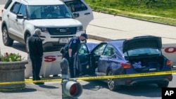 U.S. Capitol Police officers stand near a car that crashed into a barrier on Capitol Hill in Washington, Friday, April 2, 2021. (AP Photo/J. Scott Applewhite)