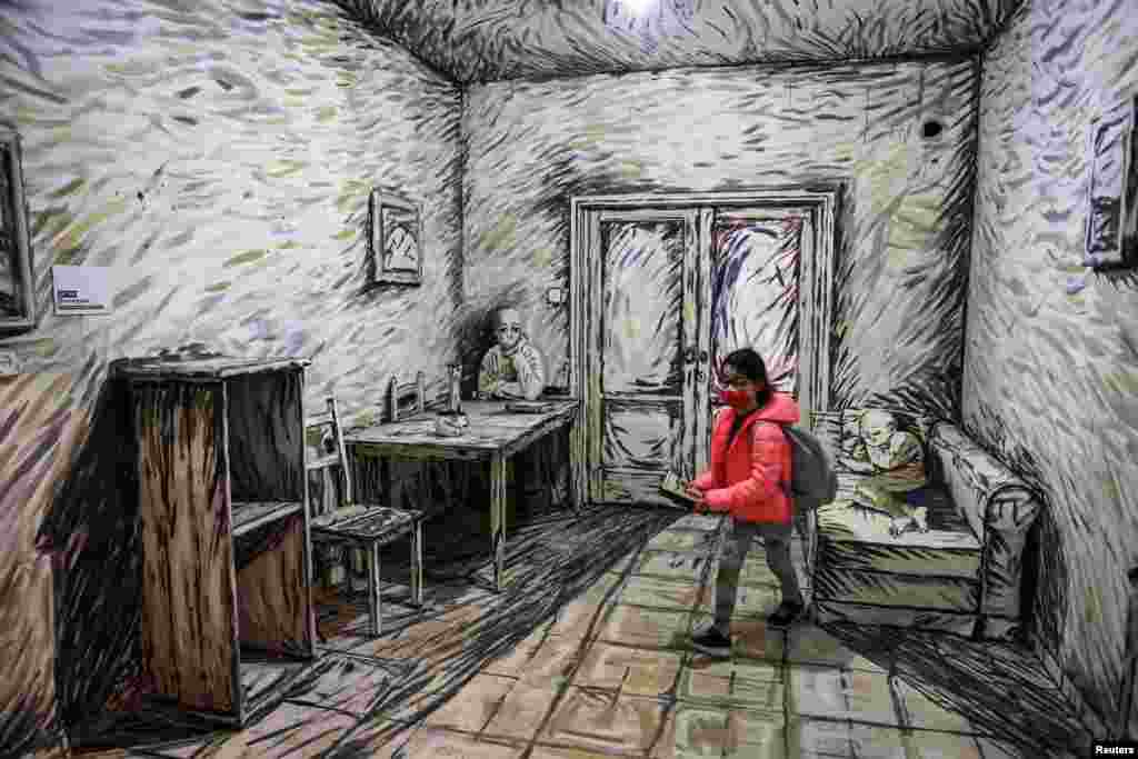 A girl walks inside a room as she visits the "Tel Aviv Pop-Up Museum," a temporary art installation in two condemned Tel Aviv residential buildings where the works of 150 artists and designers are being displayed, before the buildings are demolished, Feb. 1, 2022.