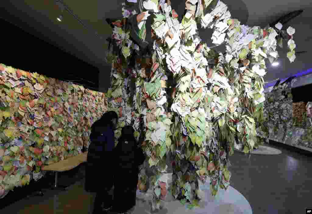 Children stand by paper messages wishing for peace in the Korean peninsula at the DMZ museum, inside of the civilian passage restriction line, in Goseong, South Korea.
