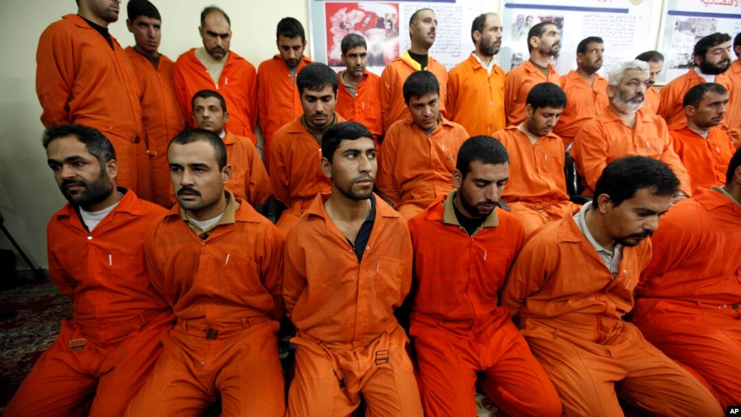 FILE - Handcuffed al-Qaida linked suspects sit in the terrorist combat and organized crime department in Baghdad, Iraq, Dec. 2, 2010.